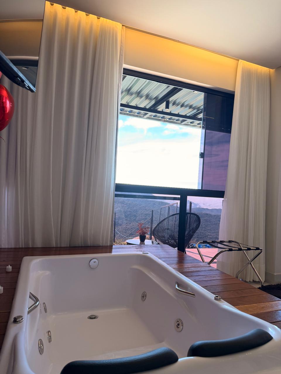 Hidromassagem romântica com decoração ao lado da janela no Loft Encanto, em Lavras Novas